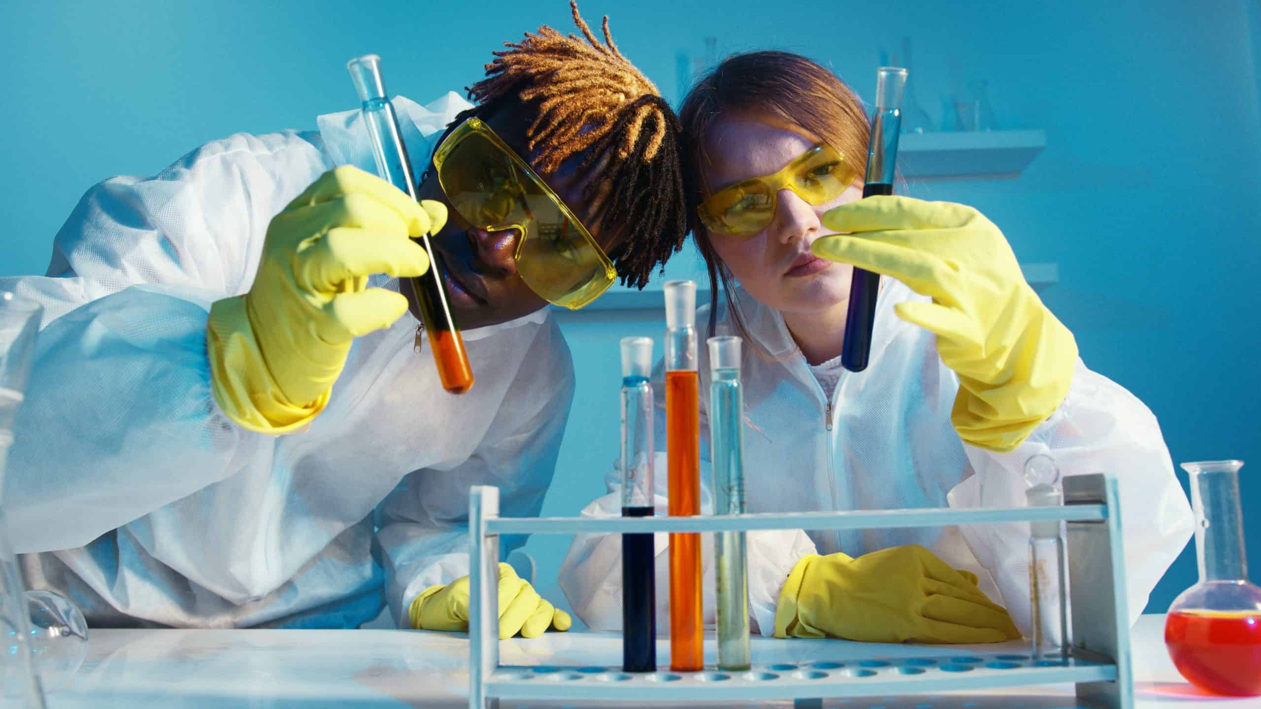 Zwei junge Menschen führen Tests im Labor durch.